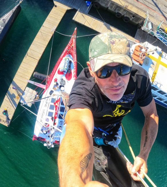 Jeff Ayliffe climbs the mast of Sam Davies' Imoca 60 in Cape Town